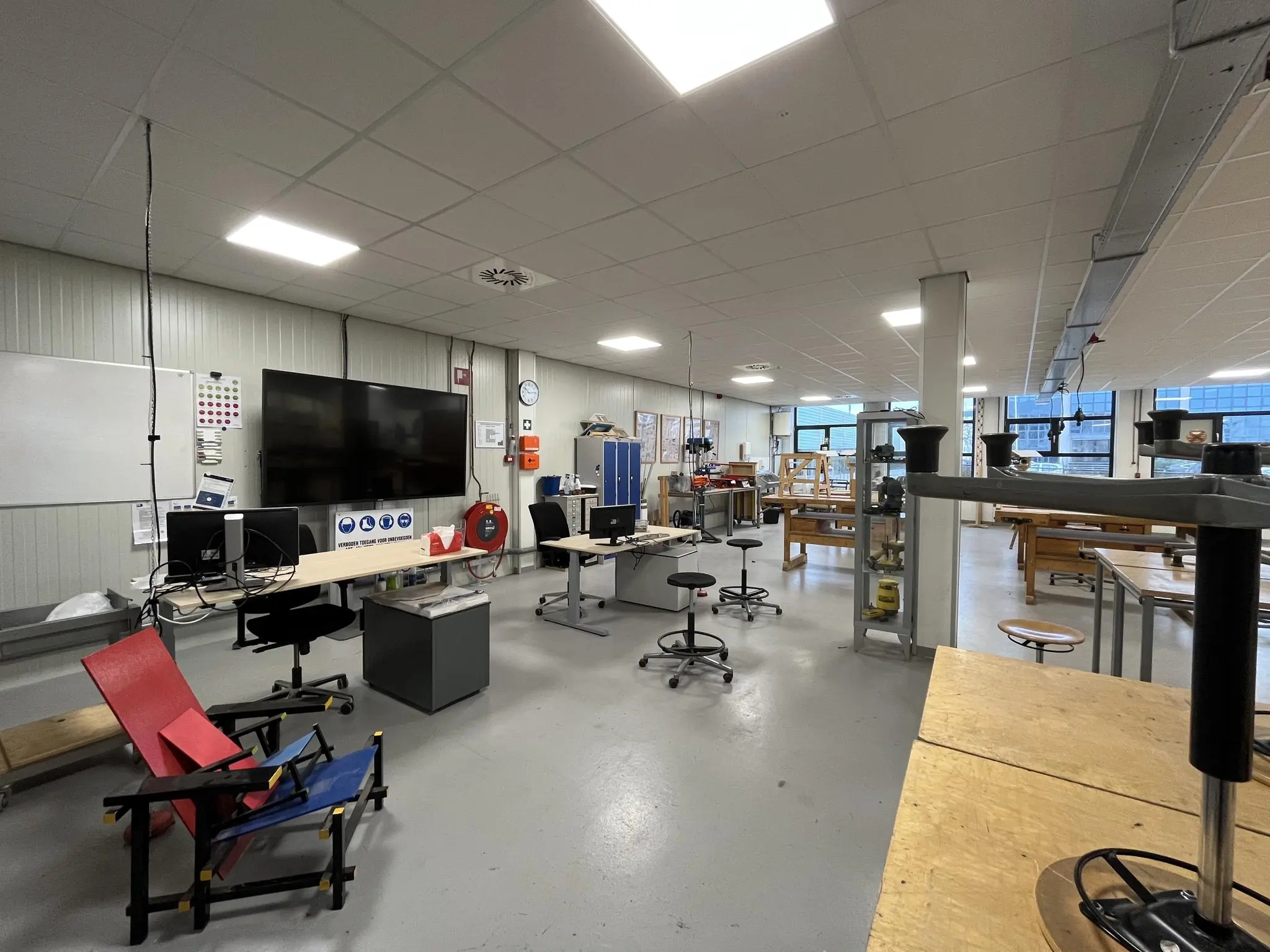 Licht en ruim technisch lokaal aan de Niels Bohrweg met werkbanken, computers en gereedschap.